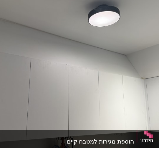 ארונות מטבח לבנים עם תאורה עליונה